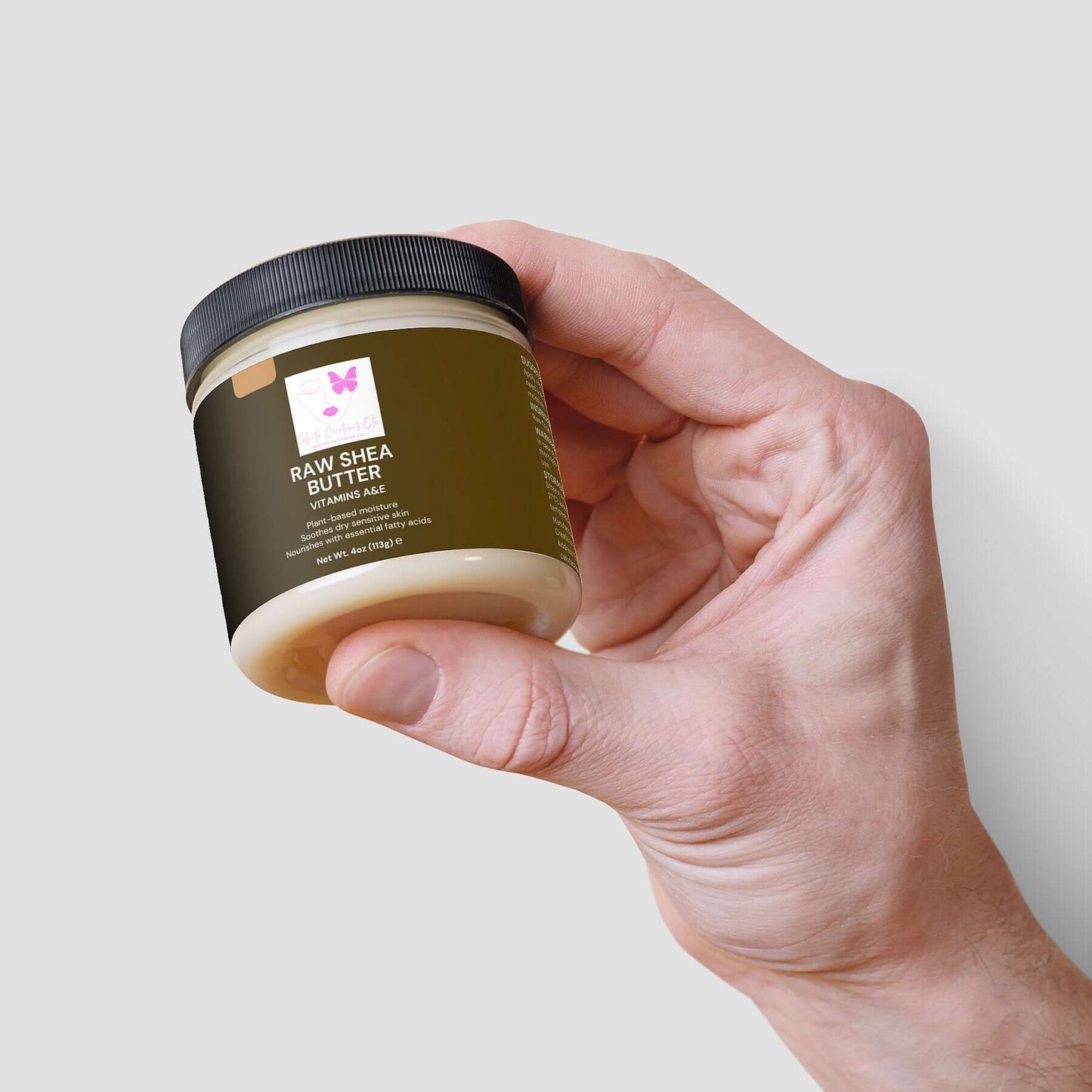 Hand holding a jar of Organic Raw Shea Butter, a deeply moisturizing, 100% vegan and cruelty-free skincare essential.