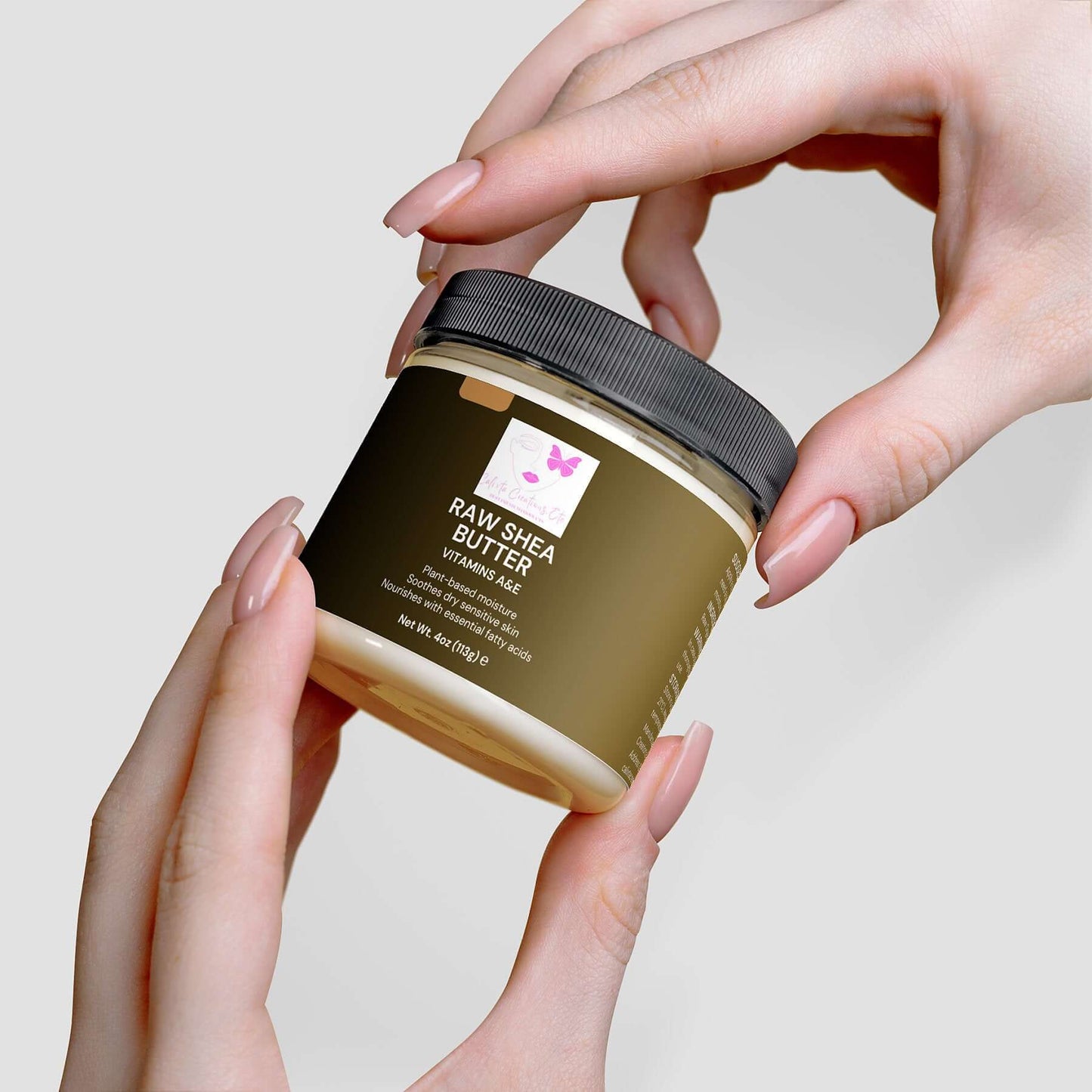 Hands holding a jar of Organic Raw Shea Butter, 100% vegan and cruelty-free, ideal for deep moisturizing and plant-based skincare.