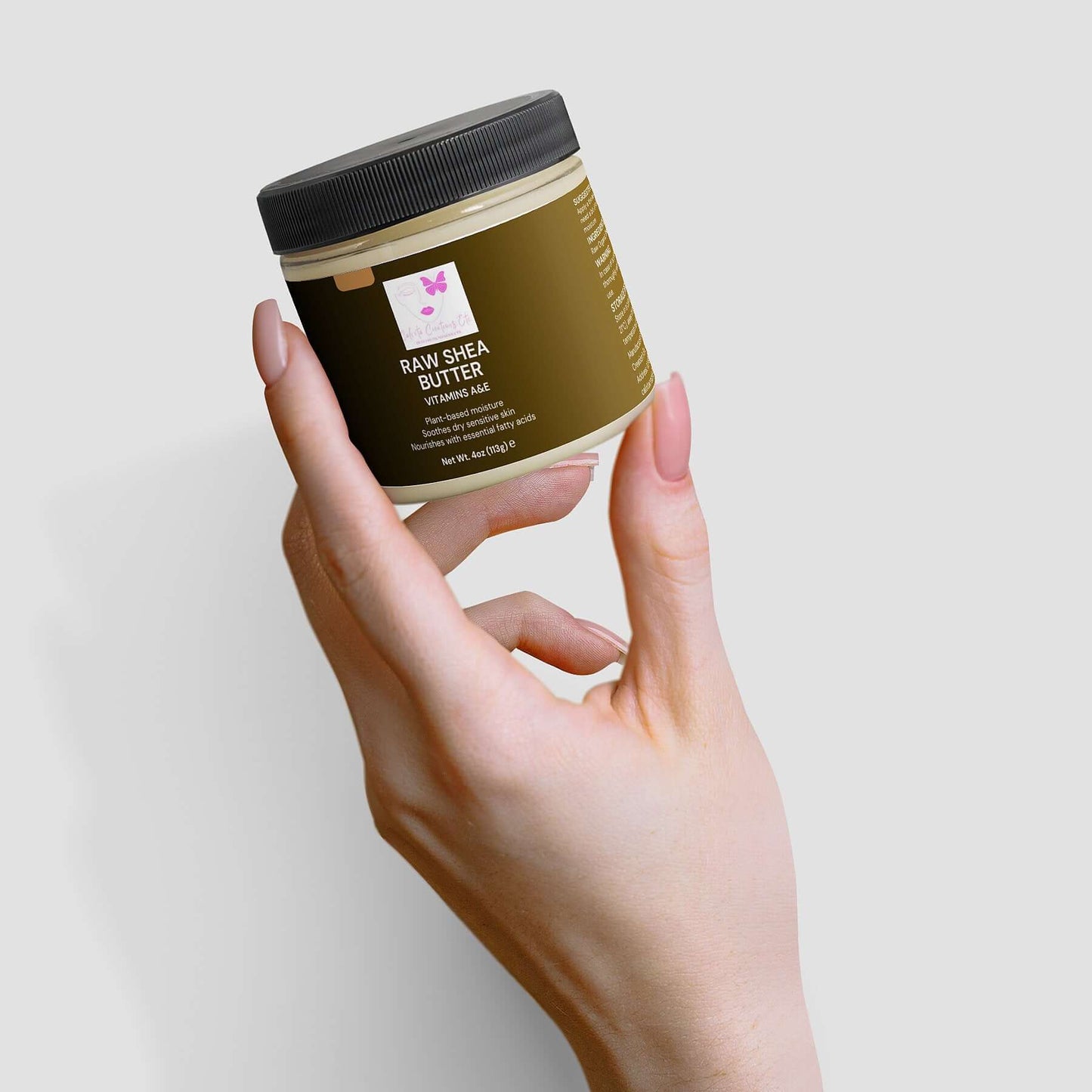 Hand holding jar of Organic Raw Shea Butter, a 100% vegan and cruelty-free plant-based moisturizer for skin and hair.